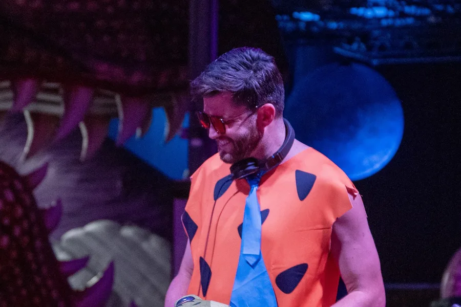 Hot T in the Coloween DJ booth dressed as Fred Flintstone