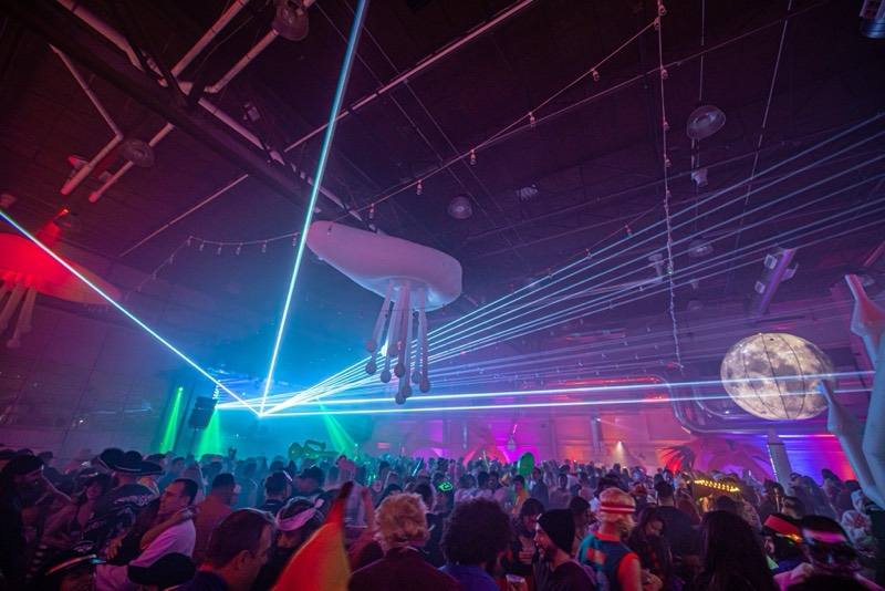 Lasers, a glowing moon, and floating jellyfish over the packed dancefloor at the Coloween costume contest in Denver