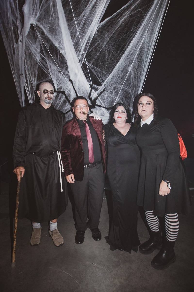Addams Family foursome posed under a giant spiderweb at Colorado's biggest adult Halloween party