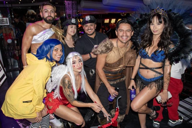 Seven friends deep: Coraline, cops, a viking, and a peacock queen at the Coloween costume contest in Denver