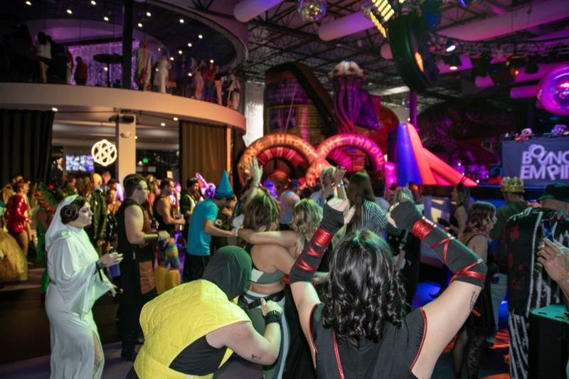 Hands up across the dance floor, inflatables overhead on the dance floor at Coloween 2025