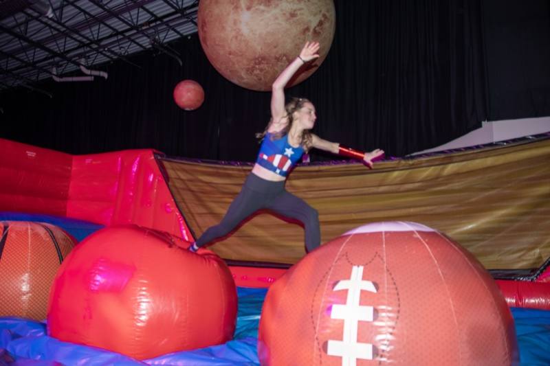 Captain America clears the giant footballs with planets overhead at Denver's Coloween Halloween party