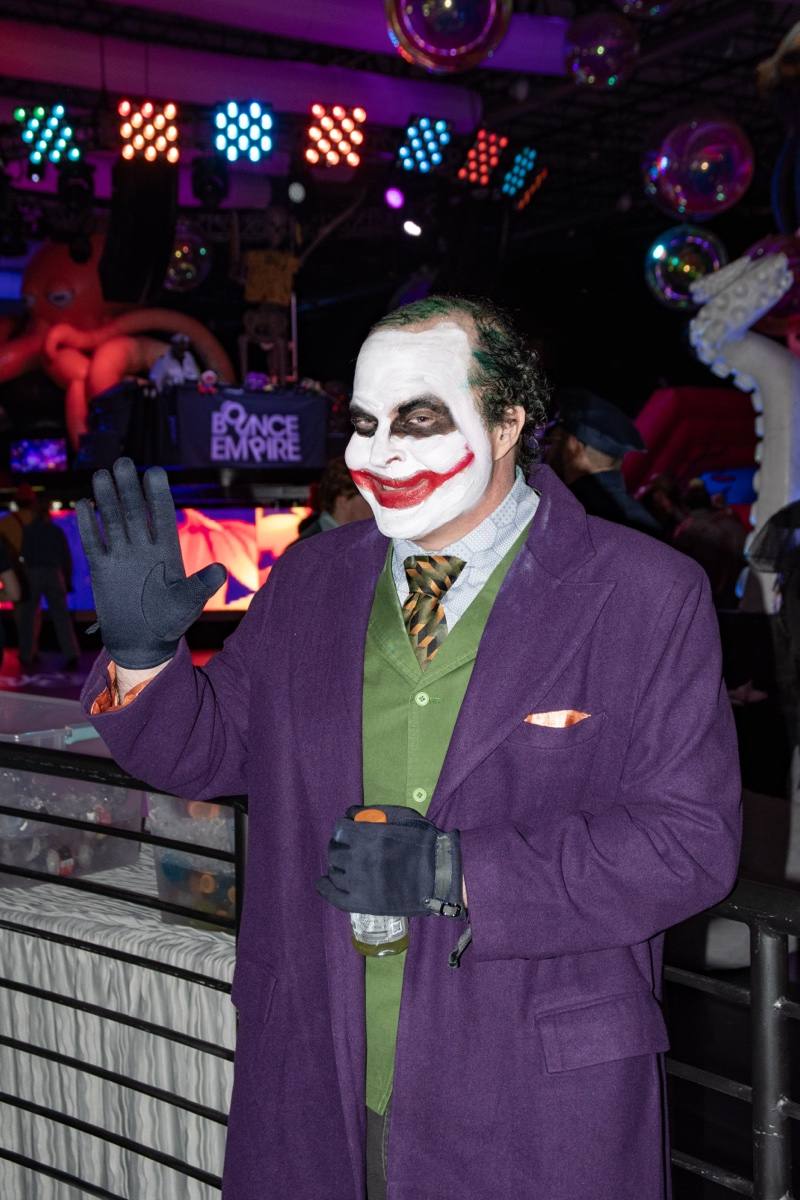 The Joker waves under stage light and octopus tentacles at the Coloween costume contest in Denver
