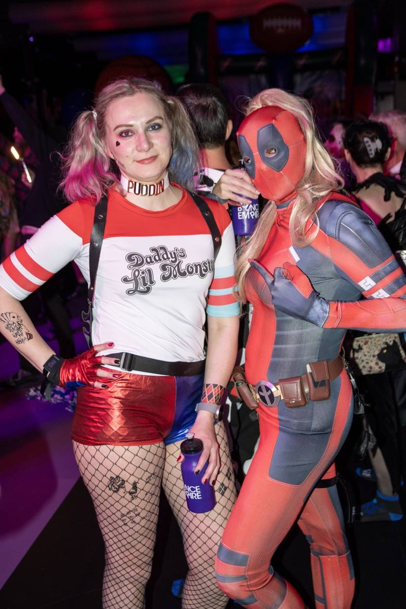 Harley Quinn and Deadpool call a truce for the camera on the dance floor at Coloween 2025